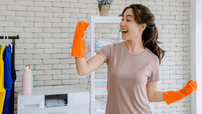 Happy woman wearing cleaning gloves, smiling while doing housework.
