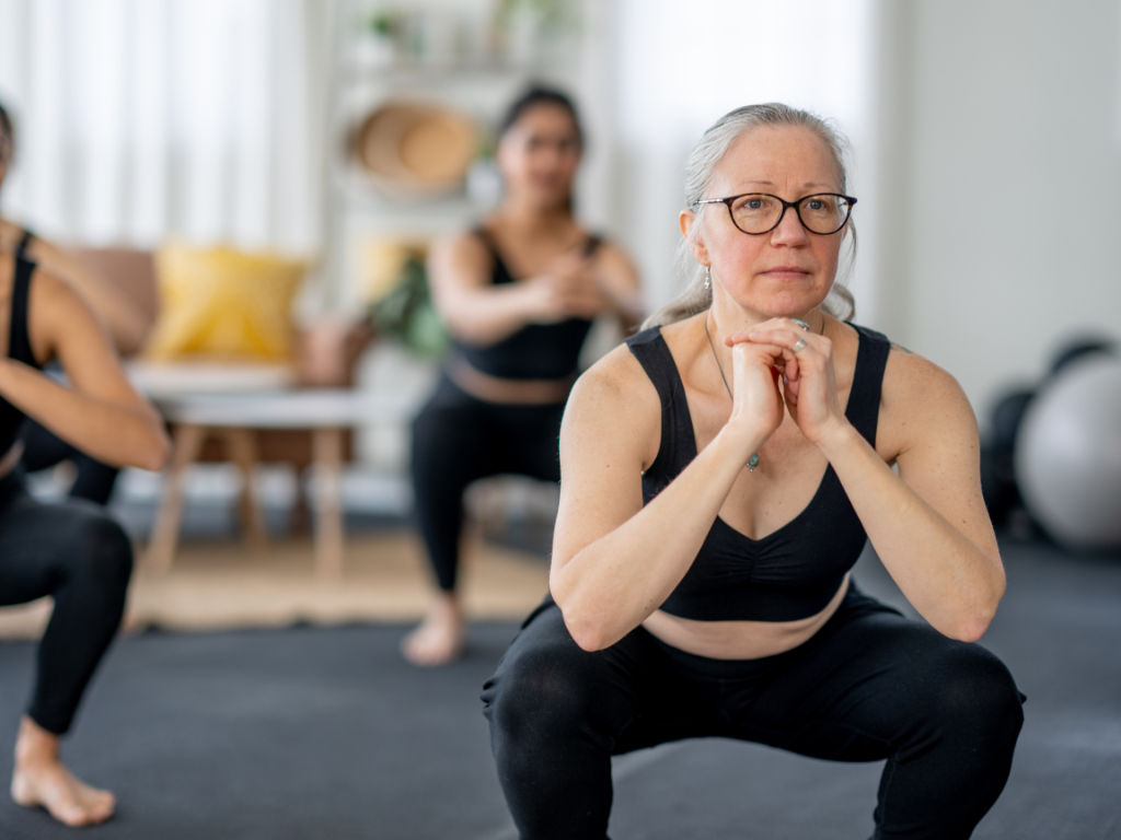 A menopausal woman performing a squat, symbolizing strength, resilience, and the importance of exercise in maintaining pelvic floor wellbeing.