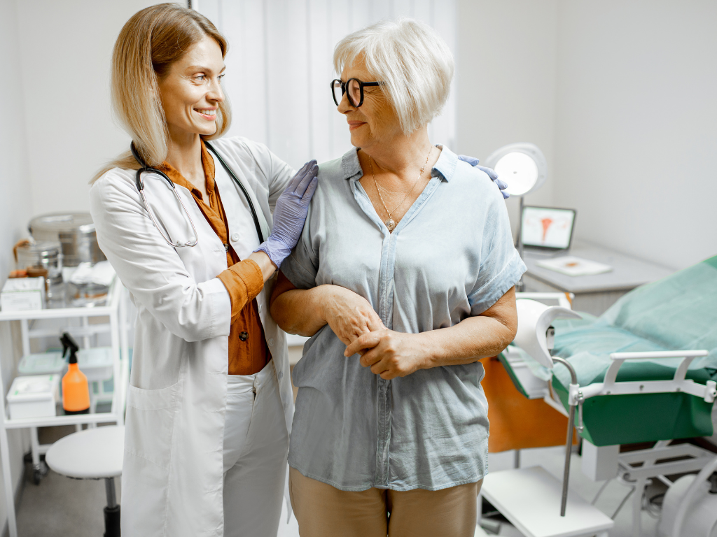 A menopausal woman discussing her health with a doctor, highlighting the importance of seeking medical guidance for pelvic floor wellbeing during menopause.